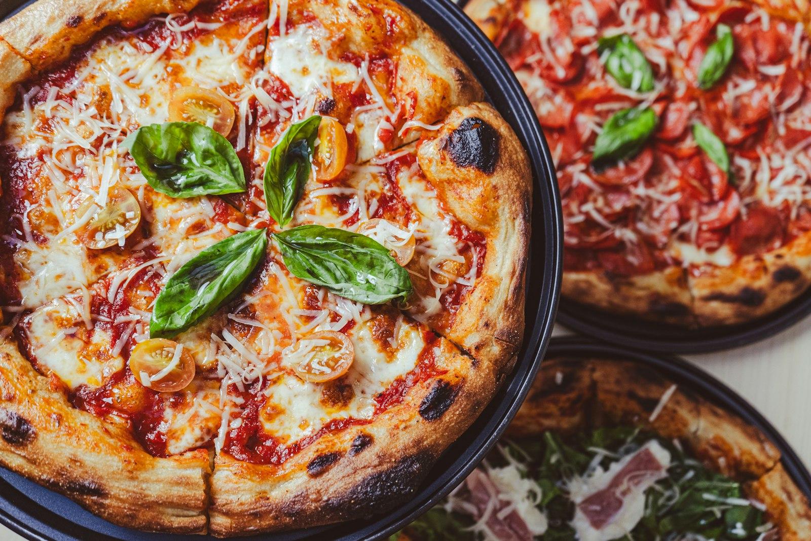 A Couple Of Pizzas Sitting On Top Of A Table jigsaw puzzle preview