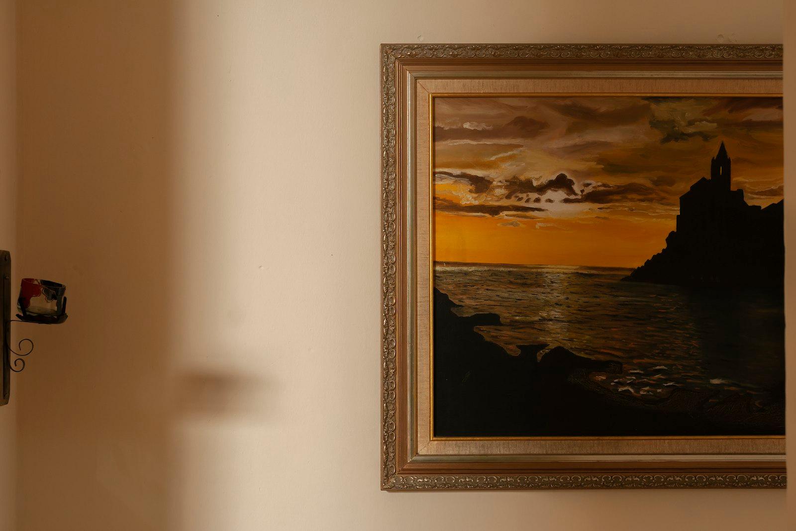 A Framed Painting Depicts A Sunset Over Water jigsaw puzzle preview