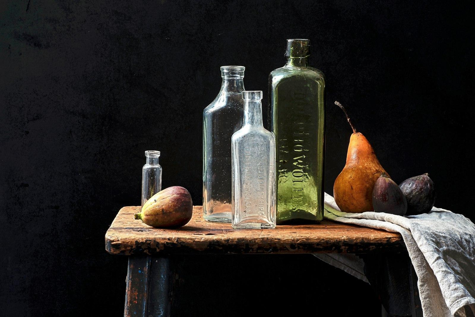 A Group Of Glass Bottles And Fruit On A Table jigsaw puzzle preview