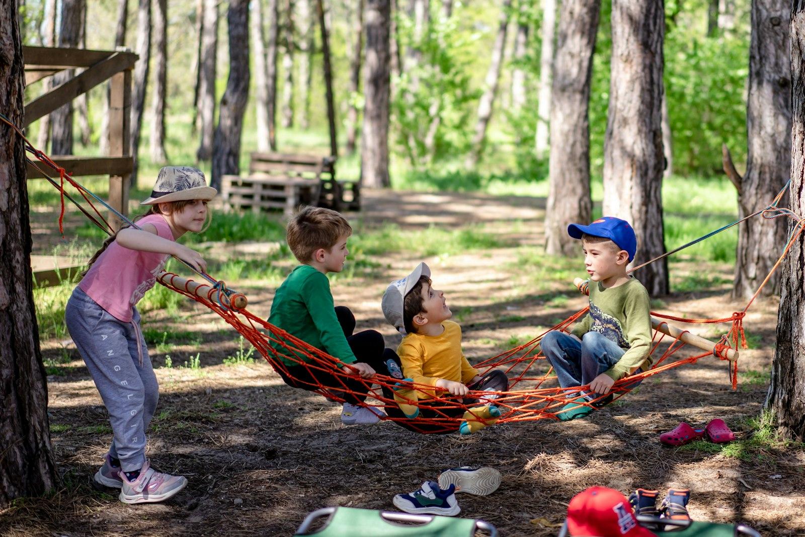 A Group Of Kids Sitting In A Hammock In The Woods jigsaw puzzle preview
