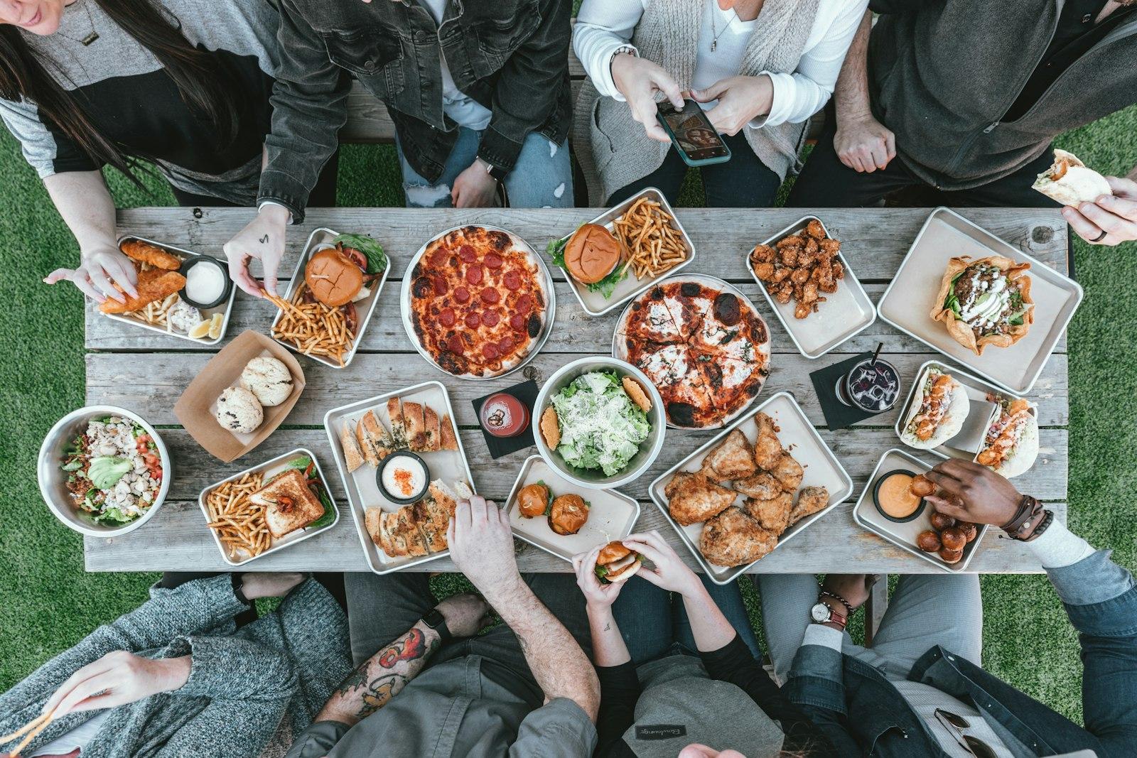 A Group Of People Sitting Around A Table With Food jigsaw puzzle preview