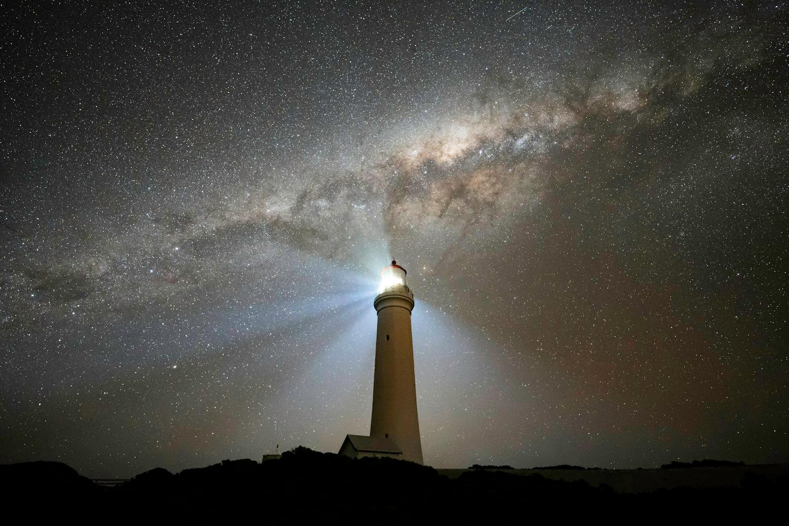 A Lighthouse Under A Night Sky Filled With Stars jigsaw puzzle preview