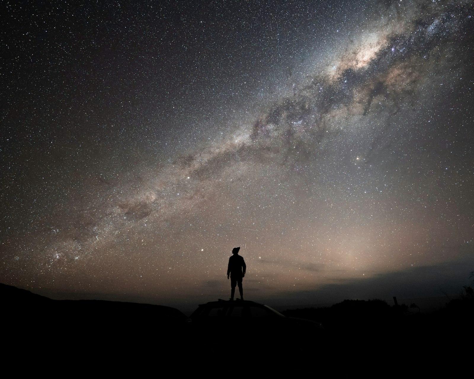 A Man Standing On Top Of A Hill Under A Night Sky jigsaw puzzle preview