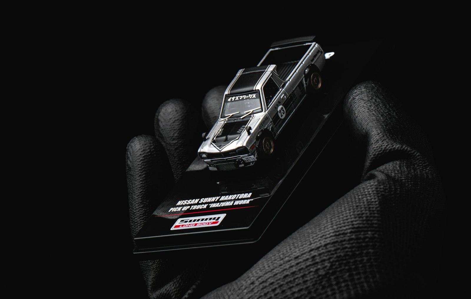 Gloved Hand Holding A Miniature Race Car Model jigsaw puzzle preview