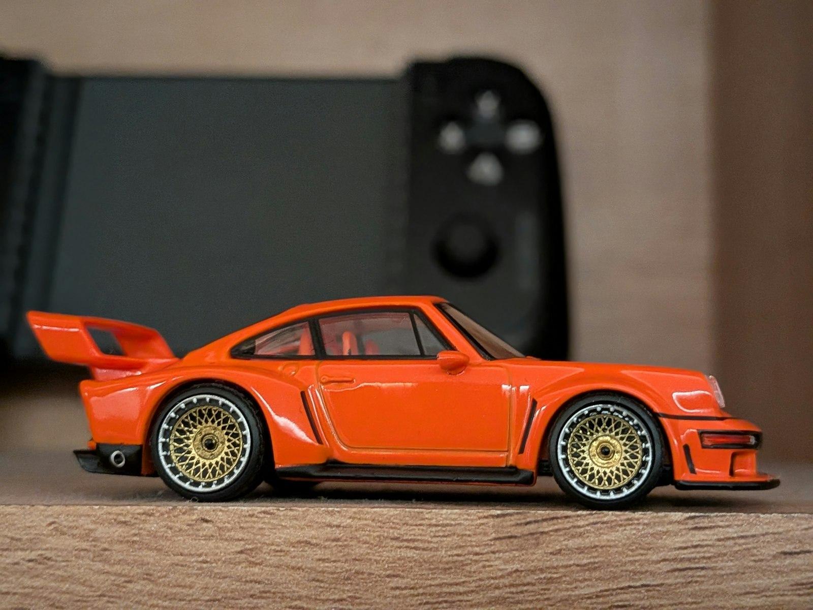 Orange Toy Car With Golden Wheels And Gaming Contr jigsaw puzzle preview