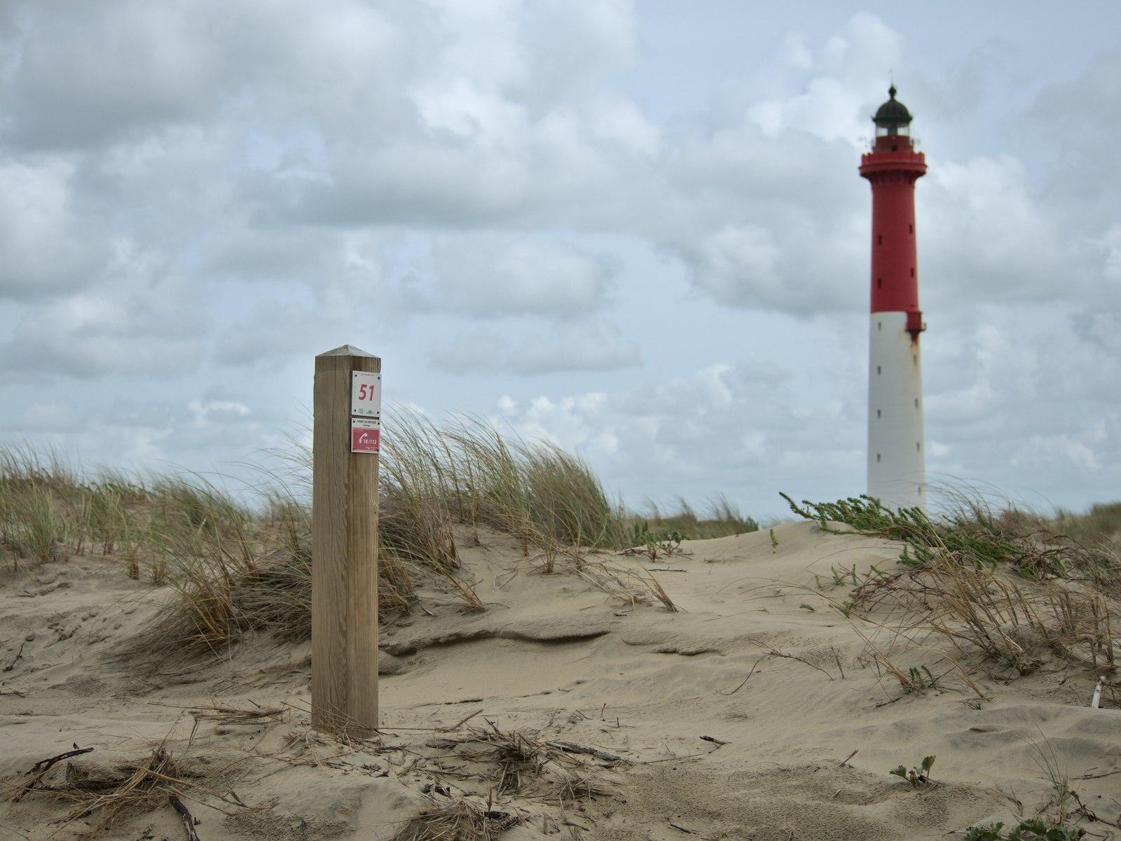 Red And White Lighthouse On Brown Sand Under White jigsaw puzzle preview