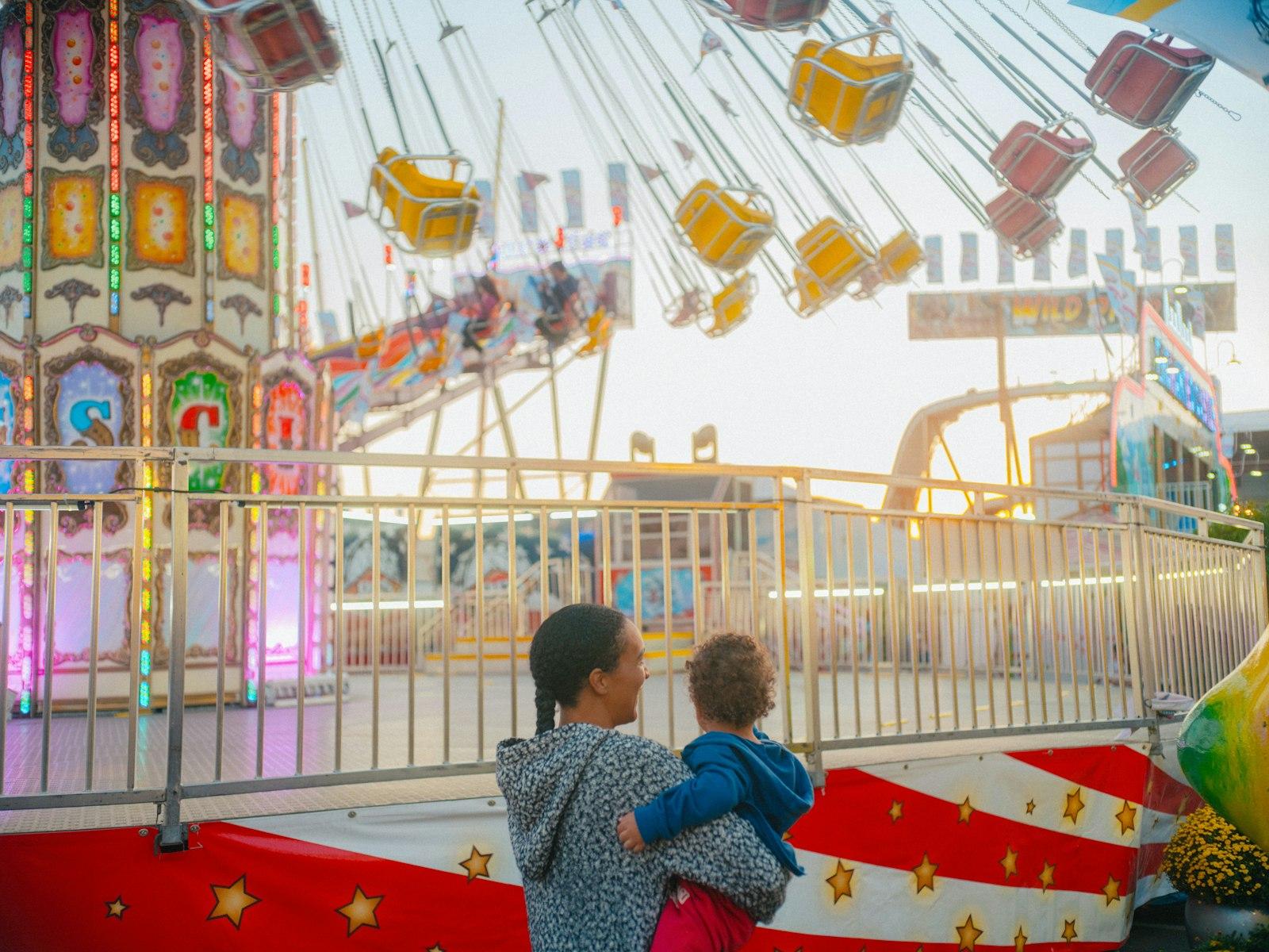 Two Children Standing In Front Of A Carnival Ride jigsaw puzzle preview