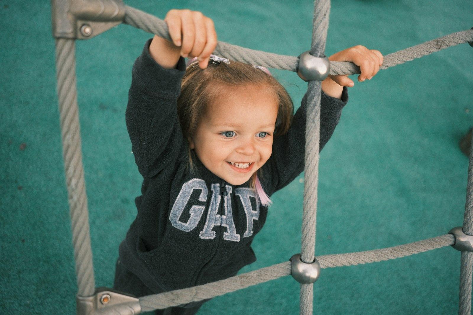Young Girl Happily Climbing A Rope Net jigsaw puzzle preview